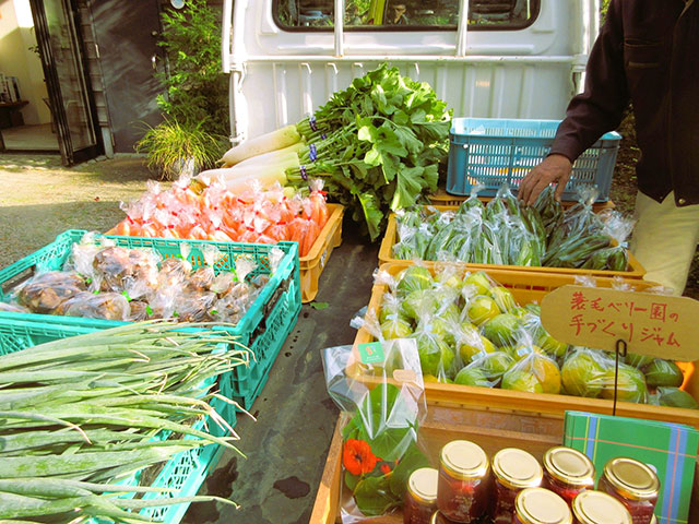 軽トラックの荷台に、蓑毛で収穫された旬の食材(野菜など)が並べられている写真